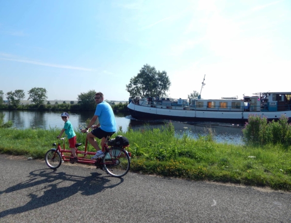 Familias: Cuentos y castillos de Holanda en barco y bici: familia en tamdem junto al barco